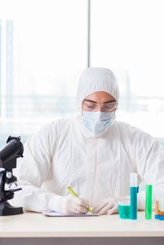 Young chemist student working in lab on chemicals