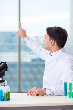 Young chemist pressing virtual buttons in lab