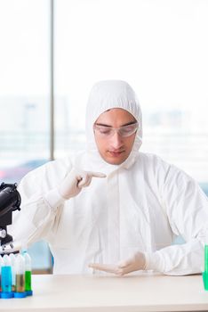 Young chemist student working in lab on chemicals