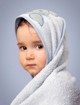 Angel look baby boy portrait with towel on blue background