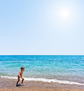 The boy runs on the beach