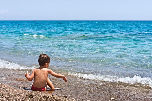 Boy playing with stones on the beach