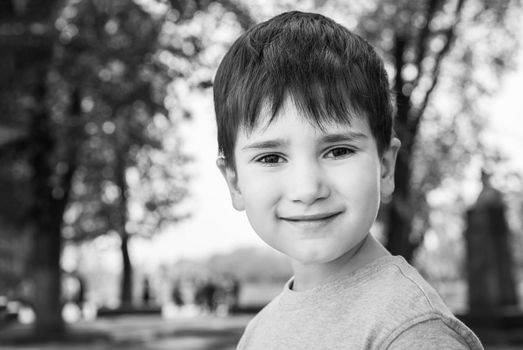 Family and happy lifestyle concept. Portrait of a little boy on the background of a blurred cityscape. 