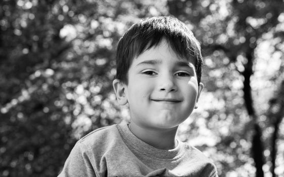 Family and happy lifestyle concept. Portrait of a little boy on the background of a blurred cityscape. 