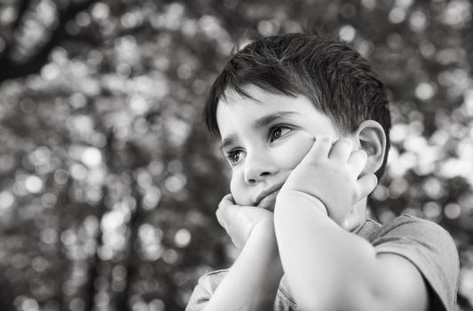 Family and happy lifestyle concept. Portrait of a little boy on the background of a blurred cityscape. 