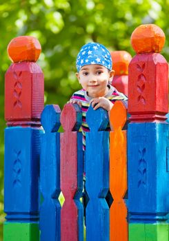 Cute young boy in bandana on playground looking in the camera