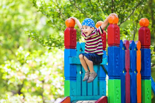 Full of energy happy young boy having fun on playground outside