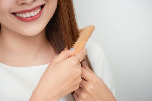 Isolated portrait of a beautiful young woman comb long hair