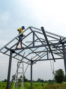 CHONBURI, THAILAND - Oct 12, 2016 Unidentified man walk and work on the steel frame of the house is under construction without protective equipment.