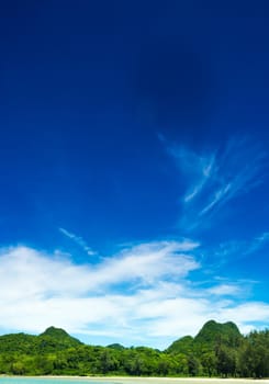 Sand beach and sea and the mountain with blue sky background