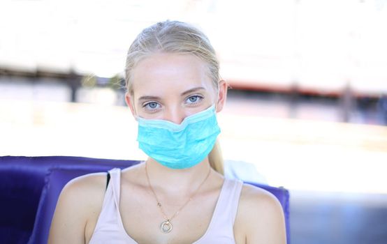 Portrait of confident young woman traveling by train, and wear protective face mask to prevent the spread of coronavirus, Covid-19