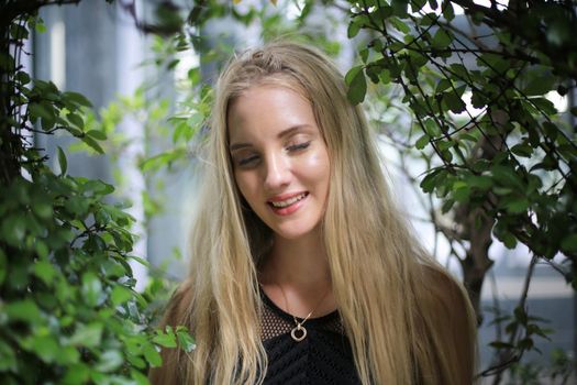 Portrait of Beautiful blonde hair girl on black dress as fashion portrait outdoor