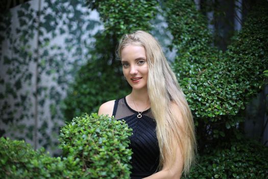 Portrait of Beautiful blonde hair girl on black dress as fashion portrait outdoor