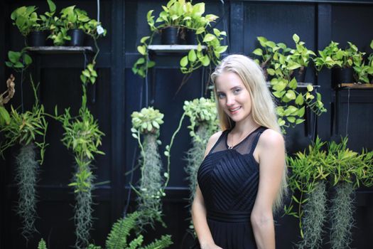 Portrait of Beautiful blonde hair girl on black dress as fashion portrait outdoor