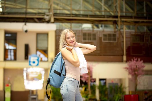 young woman waiting in vintage train, relaxed and carefree at the station platform in Bangkok, Thailand before catching a train. Travel photography. Lifestyle.