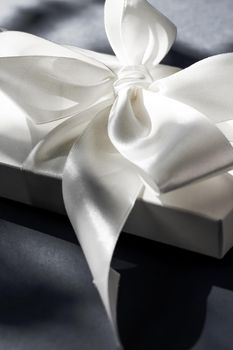 Anniversary celebration, shop sale promotion and luxe surprise concept - Luxury holiday white gift box with silk ribbon and bow on black background, luxe wedding or birthday present