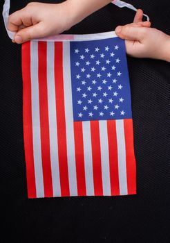 Child hand holding an American national flag in hand