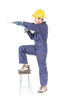 Young handyman in unifrom standing with his electric drill, Cutout isolated on white background