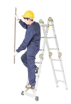 Young handyman in uniform standing on ladder construction holding wood plank on white, Cutout isolated on white background