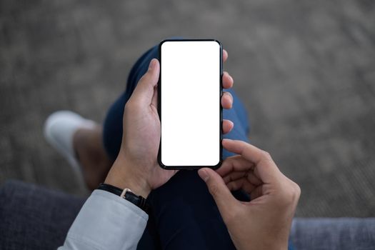A Man hand holding smartphone device with blank screen. top view