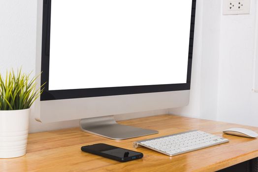 Computer monitor with white blank screen on the business desk with wireless mouse, keyboard at home office over white wall background, Photo of equipment contemporary workspace