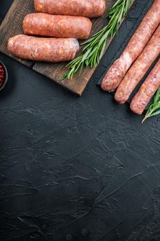 Traditional beef sausages, top view with space for text, on black background.