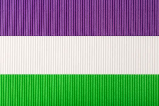 Official Genderqueer flag made of purple, white and green corrugated paper. Concept of genderqueer pride, agenderness, tolerance and respect for sexual minorities