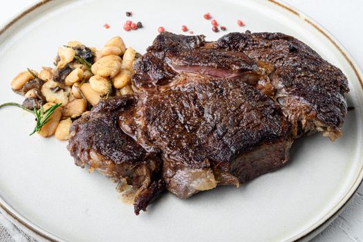 Legendary grilled rib eye with beans set, on white stone surface
