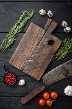 Empty cutting wooden board, with butcher knife, top view, on black wooden background with copy space