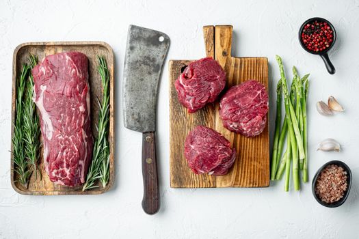 Fillet Mignon tenderloin raw meat veal and beef steaks set, on wooden cutting board, on white stone surface, top view flat lay