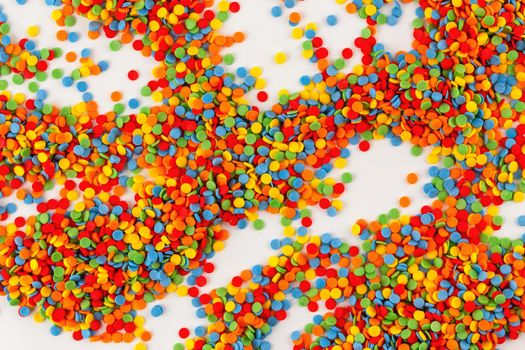 Vivid sugar sprinkle dots, decoration for cake on white background. Confectionery multicolored decorative topping.