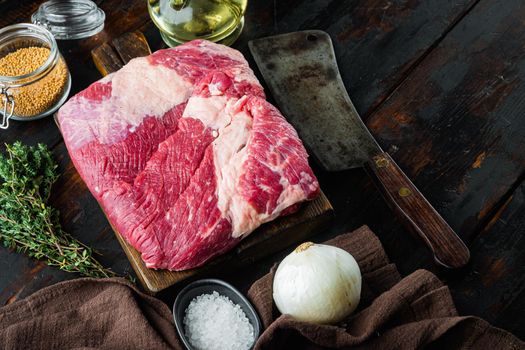 Raw piece of marble beef brisket set,with ingredients for smoking making barbecue, pastrami, cure, on old dark wooden table background, with copy space for text