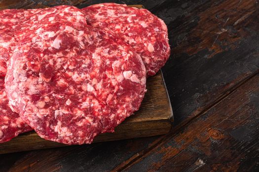 Ground Beef Patties for Grilling and Roasting set, on old dark wooden table background, with copy space for text