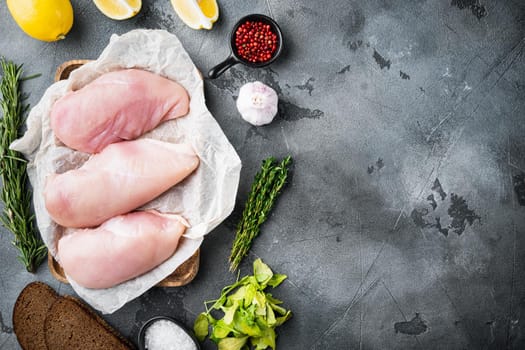 Raw crumbet chicken fillet with ingredient on grey background, flat lay with copy space