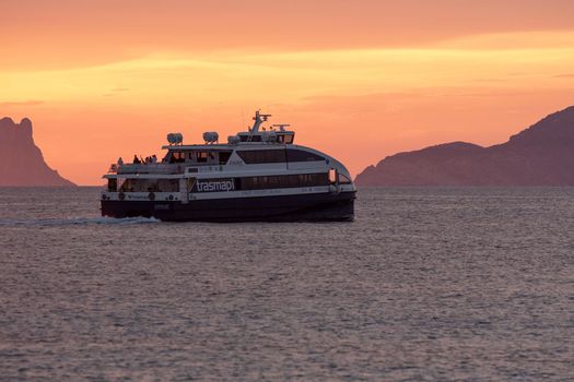Formentera, Spain: 2021 May 31: Boat from Transmapi Island of Formentera in the summer of 2021 with Es Vedra behind.