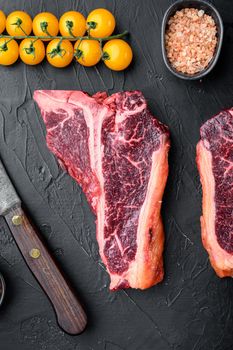 Raw fresh beef T bone steak set, on black stone background, top view flat lay