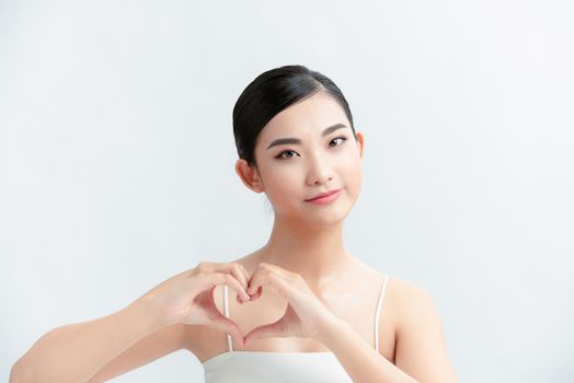Happy young Woman Holding Heart Shaped Hands Near chest