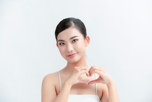 Happy young Woman Holding Heart Shaped Hands Near chest