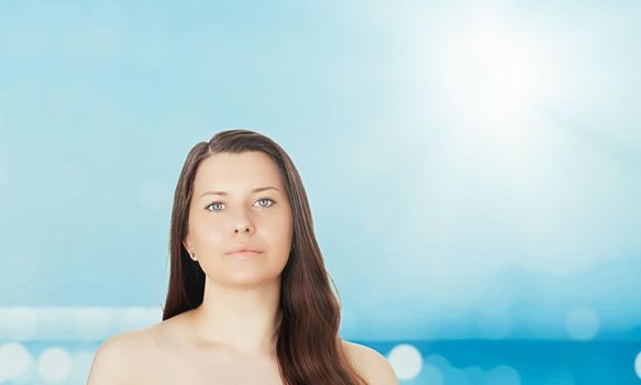 Skincare and sun protection in summer. Portrait of a beautiful young suntanned woman, blue sea and sky on background, beauty, wellness and travel concept.