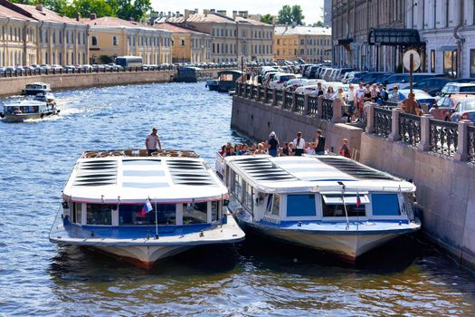 Saint Petersburg, Russia - June 10, 2021: An excursion boat carries tourists along the Neva River in St. Petersburg