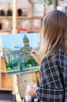 Saint Petersburg, Russia - June 10, 2021: An unknown artist paints the Kazan Cathedral on a street in St. Petersburg