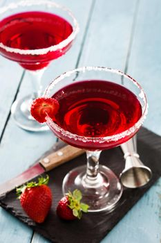 Strawberry cocktail drink in glass on blue wooden table