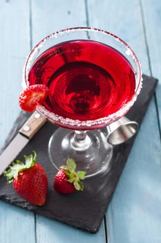 Strawberry cocktail drink in glass on blue wooden table