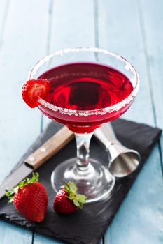 Strawberry cocktail drink in glass on blue wooden table