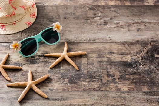 Sunglasses,starfish and summer hat on wooden background