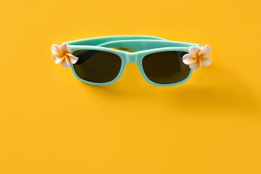 Sunglasses with flowers on yellow background