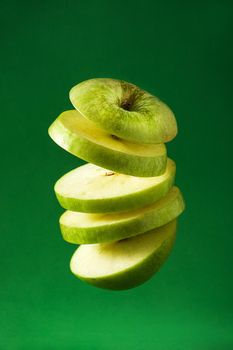 Sliced green apple cut  on green background