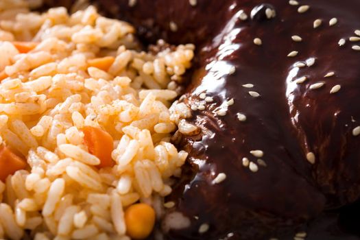 Traditional mole Poblano with rice on white plate background