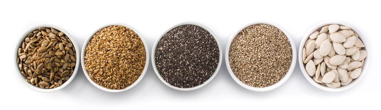 Assortment of different seeds in bowl isolated on white background. Pumpkin, linen, chia, sunflower, and sesame seeds