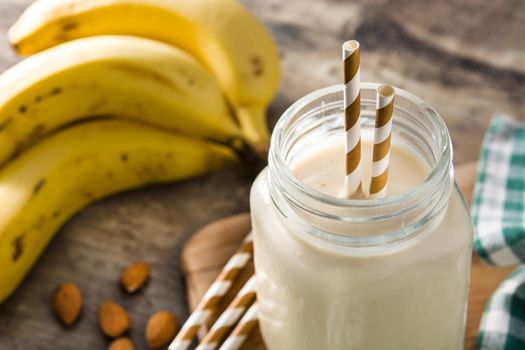 Banana smoothie with almond in jar on wooden table